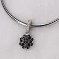 Macro shot of black enamel flower charm with zircon center on silver charm bracelet - Black