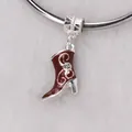 Macro shot of silver charm pendant with red enamel boot design and tiny diamond detail - Brown
