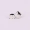 Macro view of heart-shaped hollow charms with white enamel coating for DIY bracelets - White