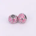 Detail showing two silver beads with pink enamel heart patterns and hollow-out design - Pink