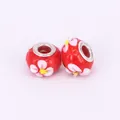 Detailed macro of two red lampwork glass beads with white flowers and silver metal cores - 15x10mm / Red