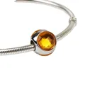 Silver snake chain bracelet featuring a faceted amber crystal bead charm in a macro view - Yellow