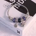 Stainless steel sunflower bracelet with purple beads and heart charms on book background - Black Sunflower Bracelet