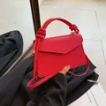 Red pebbled leather crossbody bag with a distinctive woven knotted handle and flap cover - Rose Red
