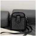 Close-up of black rhinestone crossbody bag with studs and leather snap closure - Silver