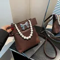 Bolso de mano marrón en piel sintética con asa de perlas y lazo grande, vista superior - Marrón