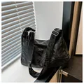 Dettaglio della borsa a tracolla in pelle stropicciata nera con fibbia in metallo lucido - Senza Ciondolo / Nero