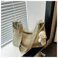 Close-up of light green pleated tote bag with a cute plush bear charm on white blinds - With Pendant / Green