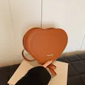 Detailed view of heart-shaped leather bag with rich rabbit embossing and silver logo - Brown