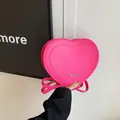 Detail of heart-shaped pink handbag with rich rabbit letter embossing and metal logo - Pink