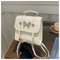 Detail of cream mini backpack with pleated texture and silver butterfly buckle - White