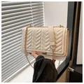 Detail of cream quilted crossbody bag with chevron stitching and golden chain strap - White