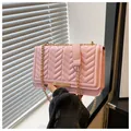 Close-up of pink chain bag with V-shaped quilting and elegant gold metal trim decoration - Pink