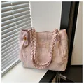 Borsa tote in jacquard rosa con manici intrecciati e nappe in un ambiente minimalista - Rosa (Con Ciondolo)