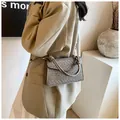 Model wearing a grey croc-effect small square bag with top handle and gold hardware - Gray
