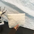 Creamy white quilted clutch bag with floral embossed texture and soft padded fabric - White