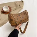 Retro braune halbmondförmige Schultertasche mit Vintage-Muster und Metallkette - Gelbbraun