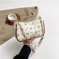 Schicke beige Unterarmtasche mit Blumendruck, Goldkette und eleganter Halbmondform - Weiß