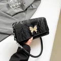 Chic black pleated shoulder bag featuring a large silver butterfly metal buckle detail - Black