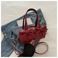 Red cylindrical barrel bag with bow decorations and detachable strap for crossbody wear - Red