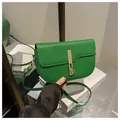 Detail van grasgroene zadeltas met gouden metalen sluiting en leren schouderriem band - Groen