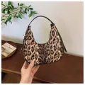 Detailansicht der Hobo-Tasche mit Leopardenmuster und Metallbeschlägen am Modell - Kaffeebraun