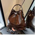 Glossy brown patent leather bucket bag with a silver butterfly buckle for women - Coffee