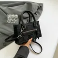 Sac bandoulière chic en simili cuir plissé noir avec deux poignées et pompons en cuir - Noir