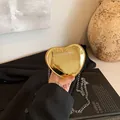 Mini hartvormige gouden lakschoudertas met een verfijnde metalen kettingriem - Goud