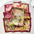 Detailed view of floral silk scarf with burgundy border and intricate botanical prints - 65cm x 65cm / Red
