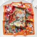 Detailed close-up of a square silk scarf with floral sunflower print and orange borders - 65cm x 65cm / Orange Red