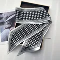 Detail of elegant black and white houndstooth silk scarf on a premium gift box - White