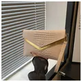 Detail of beige crocodile pattern envelope clutch with golden V-shaped metal hardware - Khaki
