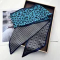 Details eines Seidenschals mit Leopardenmuster, Karomuster und geometrischen Texturen - Blau