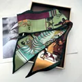 Detailed view of silk twill scarf with tropical hunter horse print in a gold gift box - Green