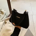 Minimalist black handbag with V-shaped texture and braided handle with gold metal accents - Black
