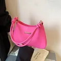 Bright pink textured shoulder bag with golden hardware and unique knotted handle detail - Pink