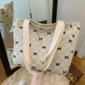 Grand sac cabas en velours côtelé blanc cassé avec motifs nœuds noirs et détails surpiqués - Nœud