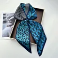 Blue and black leopard print twilly silk scarf displayed on a luxury brown tray - Bright Blue Leopard & Wavy Checkerboard Style (Style 27)