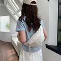 Bolso bandolera de media luna blanco roto usado por un modelo en un entorno puro - Blanco Roto