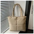 Primer plano del bolso tote acolchado caqui con costuras de cuadros grandes y asas suaves - Caqui