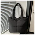Detalle del bolso tote de nailon negro acolchado con textura suave y diseño de cuadros grandes - Negro