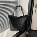 Minimalist black tote bag featuring unique rib cage embossed design with dual handles - Black