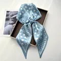 Elegant light blue silk-like neck scarf featuring white polka dots tied in a bow - Light Blue Polka Dot Satin Knotted Style
