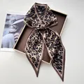 Elegant leopard print silk satin scarf tied in a bow on a minimalist brown display tray - Classic Brown & Black Leopard Print Satin Style (Style 42)