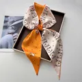 Pink and orange polka dot silk scarf with bunny pattern tied as a bow on a tray - Pink & Orange Color Block Rabbit Polka Dot Style