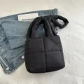 Bolso tote acolchado negro con asas suaves rellenas sobre un fondo minimalista - Negro