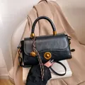 Retro schwarze Handtasche mit runder goldener Schließe und gewebtem Anhänger - Schwarz (Mit Anhänger)