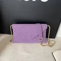 Elegante borsa a busta in pelle viola opaca con una raffinata tracolla a catena d'oro - Viola