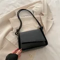 Minimalist black faux leather shoulder bag with woven texture flap and tie knot strap detail - Black